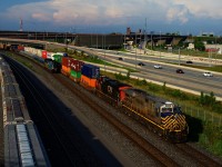VIA 669 is about to overtake CN 401 as both pass parked grain cars near the Turcot Interchange. 