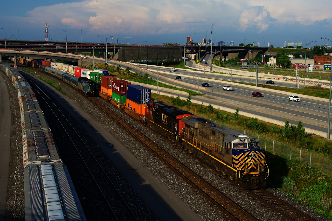 VIA 669 is about to overtake CN 401 as both pass parked grain cars near the Turcot Interchange.