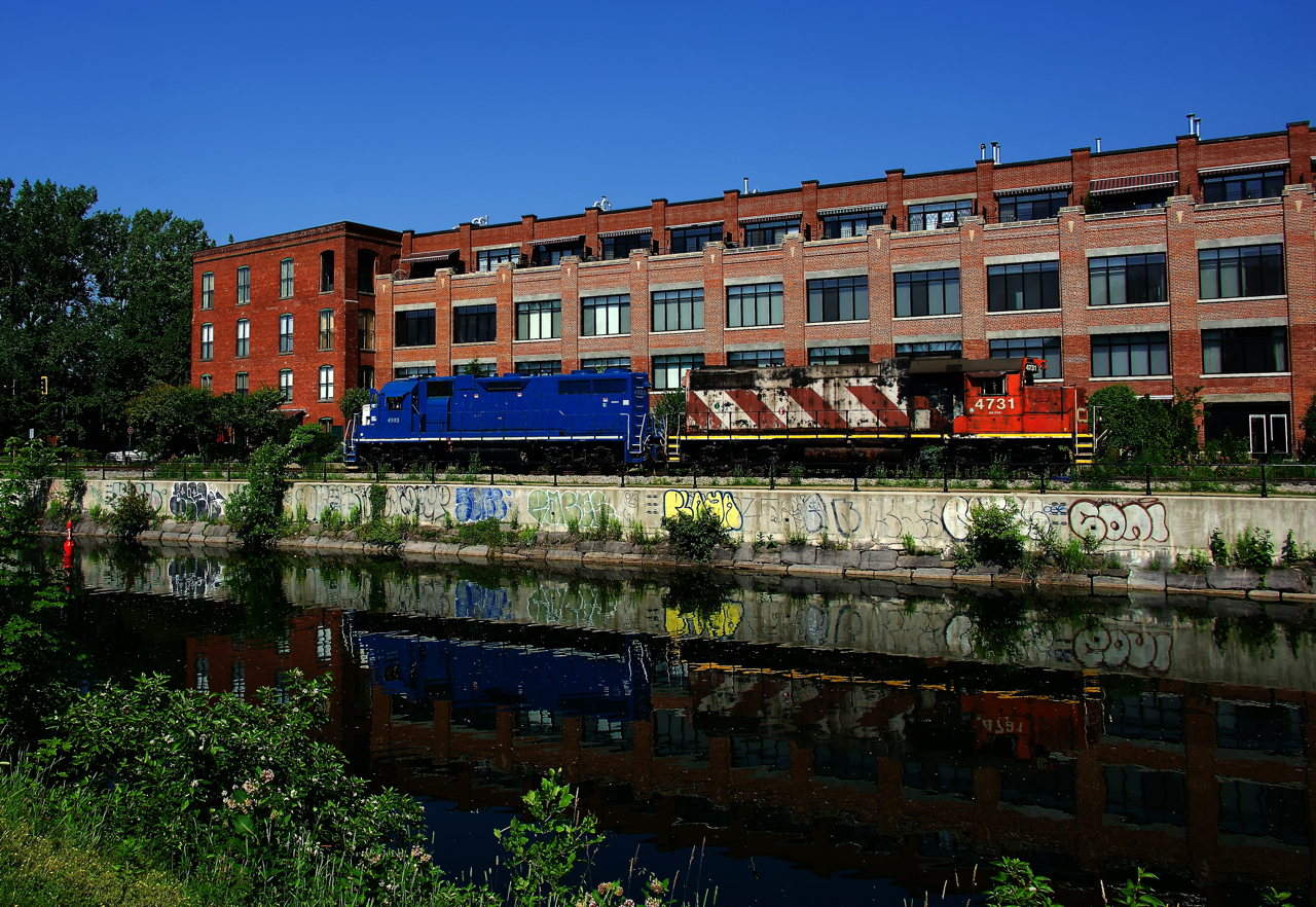 After dropping off grain cars at the only client on the East Side Canal Bank Spur (Ardent Mills) CN 4903 & CN 4731 are leaving light power as they are reflected in the Lachine Canal.