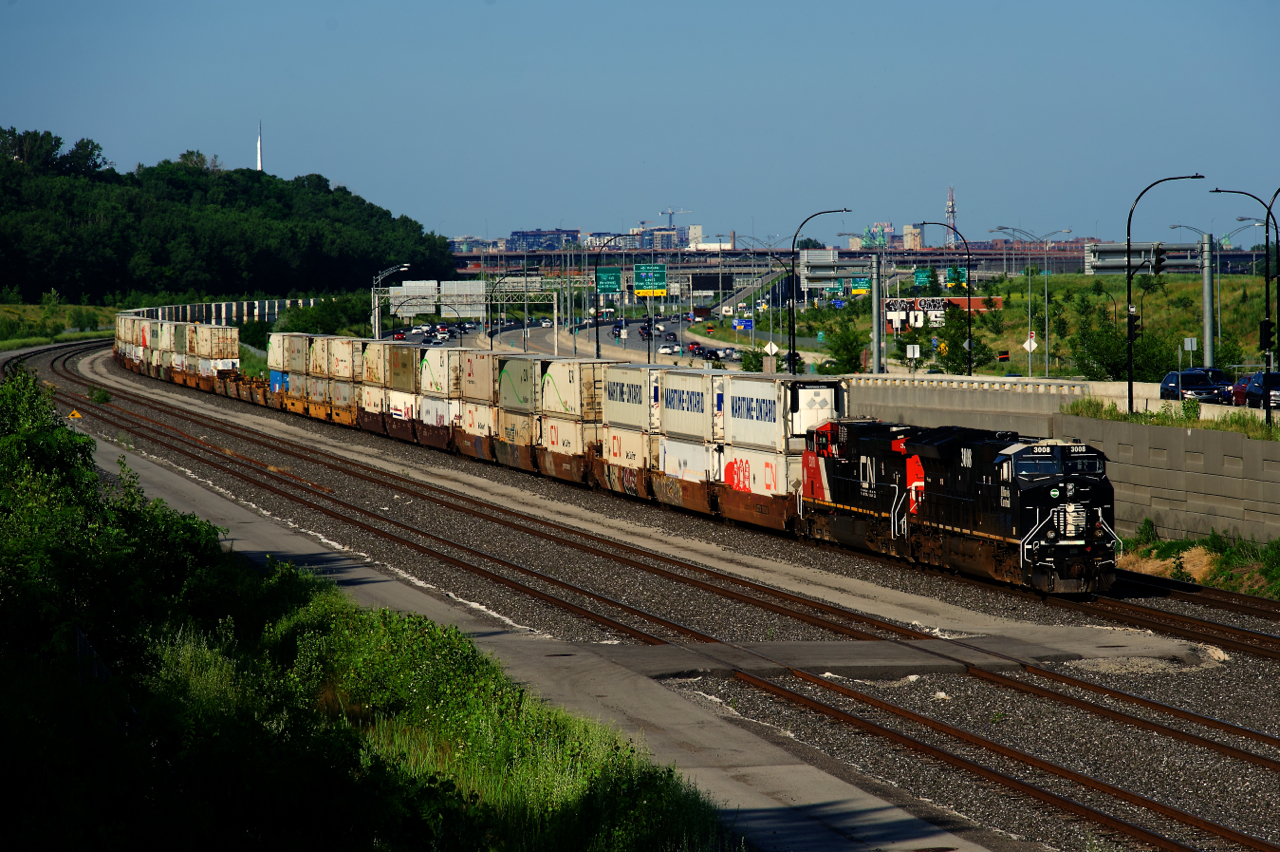Heritage unit CN 3008 and rebuilt CN 3318 (formerly CN 2609) lead a 264-axle CN X121 as it rounds a curve near Turcot Ouest. Normally originating in Halifax, this train originated in Moncton as the main line into Halifax is out of service due to numerous washouts.