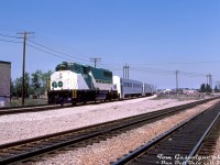 GO Transit GP40-2(W) 9810 comes off the Halton Sub at Burlington with its short 3-car train and APCU, operating on a fantrip for the US-based Electric Railroaders Association. Fantrip attendees stand around the area between CN's Halton and Oakville Subs to get their shots, across from the Burlington Station (out of view to the right, note the platform edge at the bottom right). Among the stops made that day, the train would also visit the nearby Beach Branch and stop by the <a href=http://www.railpictures.ca/?attachment_id=37233><b>Burlington Canal lift bridge</b></a> at Hargrove for a photo op.<br><br>The new GMD GP40-2W units and APCU conversions (ex-ONR FP7's converted into cab control/HEP cars) were GO's way of expanding the fleet economically as it introduced more new lines in the mid-70's (notably the Georgetown line, that <a href=http://www.railpictures.ca/?attachment_id=30566><b>opened in April of that year</b></a>).<br><br><i>Tom Gascoigne photo, Dan Dell'Unto collection slide.</i> 