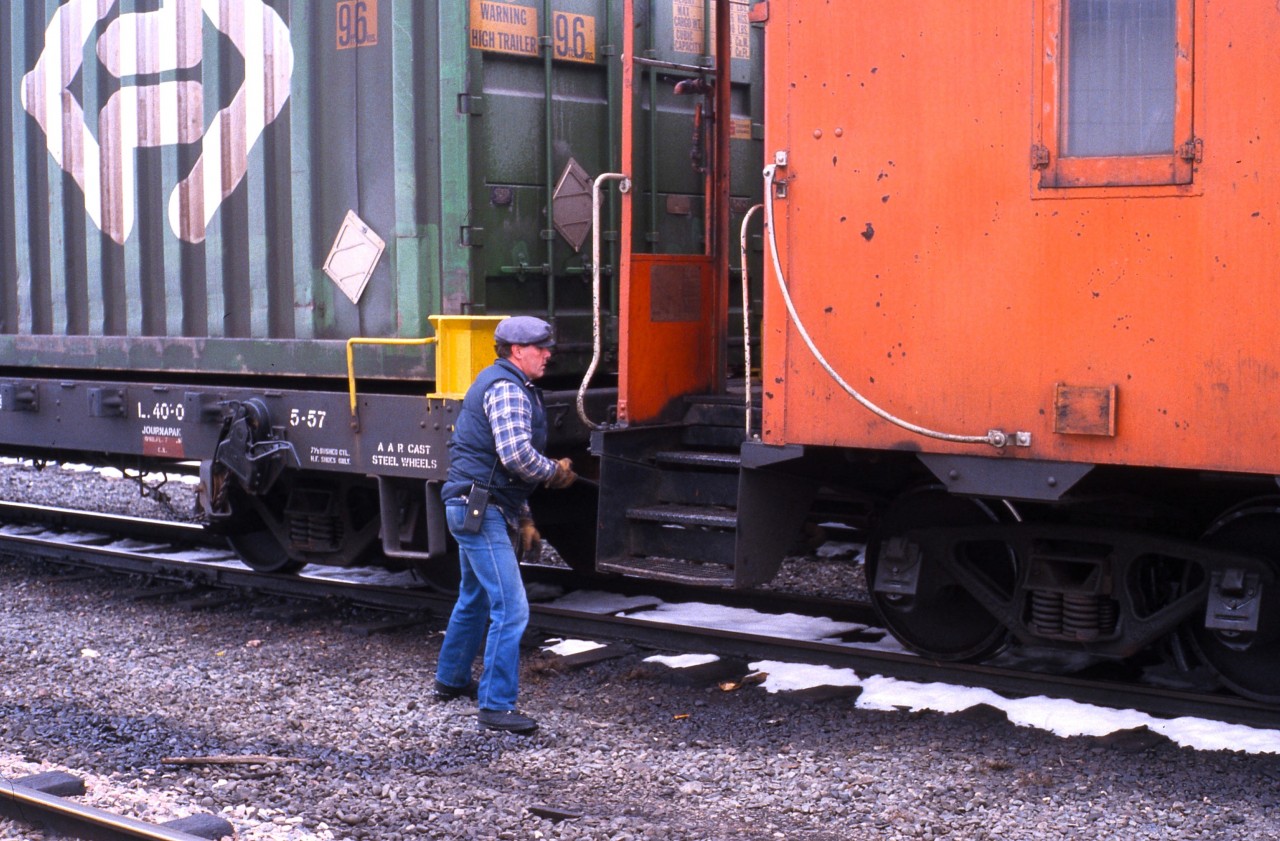 TERRA TRANSPORT TRAINMAN TURNER - In the waning days of the Newfoundland Railway, a daily east and westbound freight still operated across the 547-mile narrow gauge mainline. While waiting to board Terra Transport Mixed Extra 935 West with his friend Paul, this photographer was able to capture Trainman Gerald Turner making up the consist of an eastbound freight headed for St. John's before he too, boarded the westbound to Corner Brook. These trains were formerly known as 203 and 204 prior to the system wide introduction of the Manual Block System on July 3, 1984 and up until the very end, were mixed over the entire 138 mile Bishops Falls Subdivision. Trainman Turner was a most hospitable host, allowing Paul and I to lean out the vestibules and ride in the cupola of the caboose and upon arrival, also went out of his way to give us a ride in his private vehicle to our friend's home. Such was the kindness of the Newfoundland crews who always went above and beyond for their passengers. Trainman Turner also had the distinction of being a crewman on the very last scheduled train to operate on September 30, 1988, Terra Transport Mixed Extra 917 West. The world being as small as it is, Gerald and I reconnected after my relocation to Corner Brook from St. John's and joining his parish where we both would take up the Sunday Collection during Mass at All Hallows Church.
