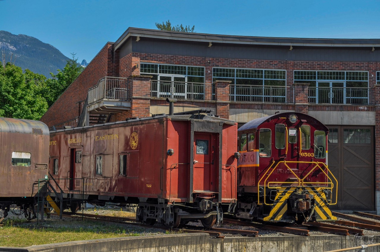 A CP van and an Alco are parked in the Museum's roundhouse.