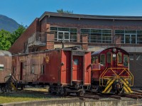 A CP van and an Alco are parked in the Museum's roundhouse.