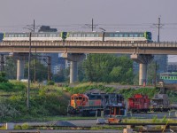 On July 17, 2023, CN 596 sits in CN's PSC yard. A REM train, which opens in a few days, passes over it towards Brossard.