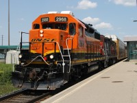 BNSF 2698 leads veteran GP9 CN 4125 on Track 1 through Bronte GO station with L554's train trailing.