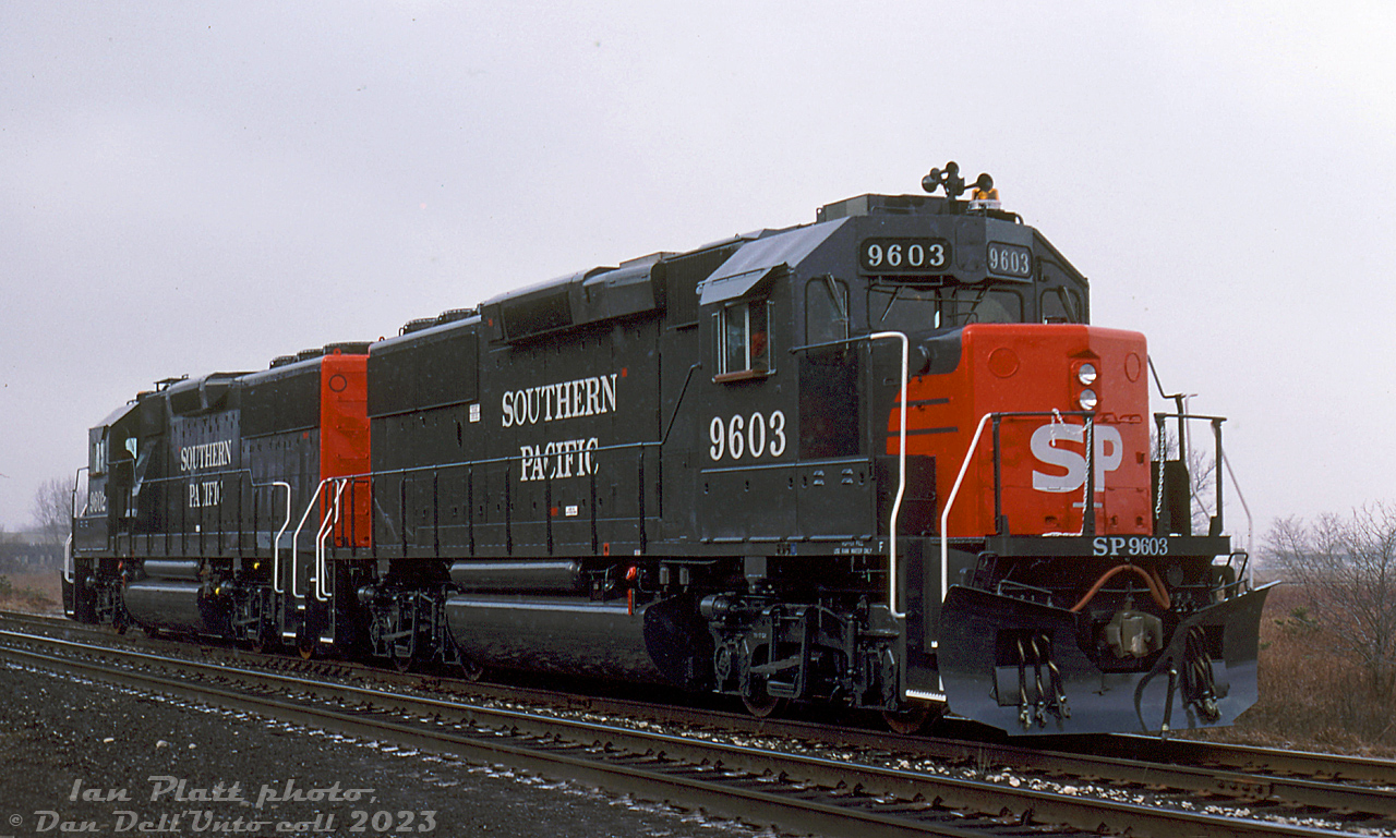 Brand new Southern Pacific 9603 and 9602, part of the first GP60 locomotive order placed (20 units for SP), sit on the "test track" outside the GMD London assembly plant. The new GP60 units were EMD's latest 4-axle freight locomotive design, featuring the turbocharged 3800hp 16-710G engine and microprocessor-controlled technology.

SP placed their first order in late 1987 (9600-9619, built 1987-88), and followed up with later orders for an eventual total of 195 units split between them and subsidiary St. Louis Southwestern (SSW 9620-9714 and SP 9715-9794), all built at GMD London. Of note, only the first order featured nose-mounted headlights. Most of SP/SSW's GP60 fleet is still in operation with the Union Pacific.

Ian Platt photo, Dan Dell'Unto collection slide.