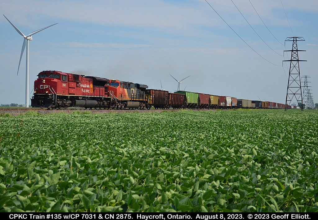 CPKC Train #135, with CP SD70ACu #7031 and CN ES44AC #2875, speeds across the flatlands of Essex County just west of Haycroft, Ontario on August 8, 2023 while traversing the CP Windsor Subdivision from London to Windsor.  Not many trains on the line anymore compared to the mid-90's, but you do the best with what they give you.