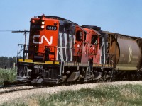 When returning from eastern Alberta, the grain extra at Kerensky would have to make a stop to get the south connecting track switch and then line it back to normal after having passed it. Not certain exactly when, but, shortly after this photo time, a spring switch was installed so that returning trains from the Coronado could trail through the switch without stopping. In this photo, the tailend brakeman has only moments before given the signal that the switch is lined and the engineman is slowly getting the train of grain on the move as it negotiates the big curve that will take it south and down to cross the Redwater river.