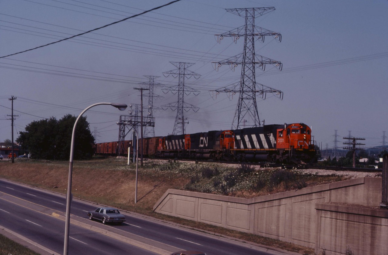 With its usual block of reefers for the Ontario Food Terminal near Mimico Yard, an eastbound accelerates away from Aldershot and crosses Plains Road in Burlington. Unfortunately, this traffic was lost to the trucks in the 1980s and today there is no rail service to that facility. CN rostered 44 C630m units; only 2001 and 2000 were equipped with dynamic brakes.