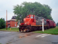Not long after a summer downpour moved through Waterloo, Ontario, the CN 15:30 Kitchener Job slowly makes its way to Elmira on the Waterloo Spur. CN GP9RM 7028 leads one hopper and caboose 79883 as it’s about to cross John Street, which is the street I grew-up on that had originally started my interested in trains.