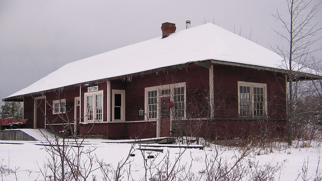 When viewing  Arnold Mooney's photo of former CN Sutton station, I was reminded of my only trip to the area back during the Holiday season of 2005. I couldn't help but to remember how I was nearly 20 years younger then, and how frigid of a day it was with storm clouds moving in fast. To say the least, it was a winter wonderland driving up. But, also present day - another timeless attempt for a time machine photo. Seems like this old building, no matter where it lies when Arnold shot it in 1976 or in 2005, that some sort of foliage seems to be growing around the station. Difficult angle, as my feet were frozen by this point after breaking through many icy puddles that were water and mud. But, the building itself while in much better shape than in 1976, did show some maintenance was already required in 2005. Still, the old station looked great as it rests in retirement now at the Georgina Museum in Keswick.