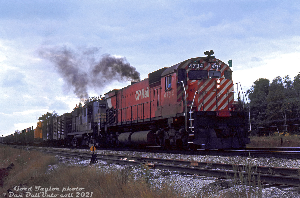 CP M636 4734 and RS18 8757 operating on an eastbound freight (green flags and class lights denote this as the first section of a timetable freight) smoke it up as they accelerate their train out of Guelph Junction, passing by the derail near the east end of the south siding. The head end has two stock cars, a dimensional load of construction machinery (possibly a large off-highway truck) on a flatcar, and empty open autoracks.

Gord Taylor photo, Dan Dell'Unto collection slide.