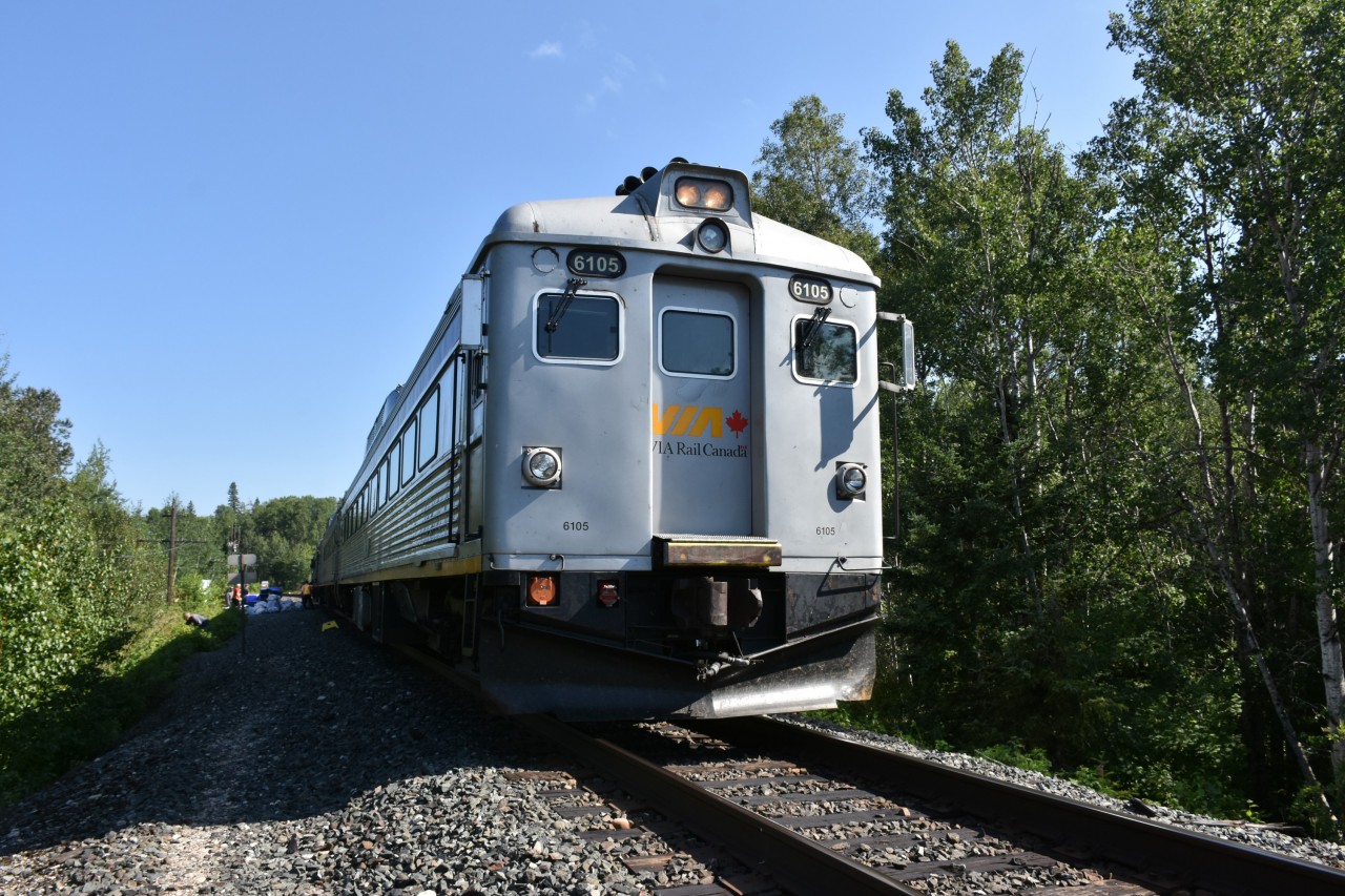 VIA 185 The Sudbury to White River train has stopped at CP Swanson to exchange arriving and departing guests, and load/offload baggage and supplies for the famous Lodge Eighty Eight at Mile 88.8 CP White River Sub. 
While the VIA crew assist guests with gear at the baggage car, one passenger at left can be seen picking raspberries which were thick on the bushes everywhere along the line. 
Those clear plastic bags down by the baggage car are filled empty water bottles and beer cans being returned for deposit/recycling. Someone will pocket a few dollars from that load!!! :-) 
VIA 6105 is sporting the VIA Rail Canada logo on the center of the nose door, and running numbers stenciled at the lower front corners making it a little less stealthy than VIA 6250 seen in a photo I posted yesterday. I much prefer the noses of these VIA Budd cars with yellow paint. 
Another trip with perfect weather. :-)