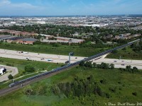 VIA Rail #1 "The Canadian" has just come up from Union Station via the Newmarket Sub, and is beginning its reverse movement onto the CN York Sub for the trip east to Doncaster (and up the Bala Sub). Here, rear dome-observation park car Kootenay Park leads the 21 car consist off the Newmarket Sub, splitting the signals at Snider North as the train crosses back off the Highway 407 ETR overpass. A York Region Transit bus (LFS 1710) can be seen running the Route 760 Vaughan Mills / Wonderland route, originating from the cluster of new condos (around Vaughan Mills) and the faint roller coasters of Canada's Wonderland visible in the distance.
<br><br>
Head end of the same train: <a href=http://www.railpictures.ca/?attachment_id=52620><b>http://www.railpictures.ca/?attachment_id=52620</b></a>