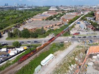 Signs of the times: KCS units, and SD40-2's floating around! After pausing at Emery for the light, CPKC train #421 heads north on the MacTier Subdivision over the Islington Avenue grade crossing near the Vaughan-Toronto border. CP AC4400CW 9766 leads KCSM ES44AC 4752, CP SD40-2's 6080 and 6045, and a sizable freight in tow. There was a time when KCS "Southern Belle" units were rare on CP and SD40-2's were common, it looks like the tables have turned somewhat!
<br><br>
Harnessing the power of the mighty drone gets a bit more in view here compared to that fellow at the grade crossing shooting the train from the ground: at the bottom right, new condos are going in where there once was a small golf course. On the left is CN's Halton Subdivision, currently between trains. At the upper left, the "Vaughan skyline" of new condos and highrises around the Vaughan Metropolitan Centre subway are visible. In the upper right are likely highrises along the Weston and Finch area of North York.
<br><br>
Here's a <a href=http://www.railpictures.ca/?attachment_id=49393><b>Reg Button photo of the same spot in 1984</b></a>, little has changed with some of the surrounding businesses including LiftKing and the garden centre.