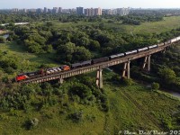 Looking like a miniature model and almost fitting the entire train on the bridge, CN GP38-2W 4770 and GP38-2 4717 lead their short 10-car local #529 eastbound high over the Humber River in the evening light, heading back to MacMillan Yard after switching some of the industries along the Weston Sub.
<br><br>
Built in the early 1960's as part of CN's "Toronto bypass" project, this single track bridge was constructed to span the Humber River on the northern reaches of Toronto, just inside Vaughan Township, as part of a new railway line (the Halton Subdivision) connecting the new <a href=http://www.railpictures.ca/?attachment_id=51354><b>Toronto Yard</b></a> (today's MacMillan Yard) to CN's existing Brampton Sub (today's Weston/Halton Sub) near the new satellite city of Bramalea (at "Halwest"). The line, a mix of double and single track since its inception (with many sections expanded to double- and triple-track since), remains single tracked over the Humber River bridge nearly six decades later. 