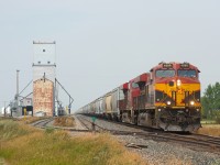 With a hazy sky due to wildfire smoke, a loaded CPKC grain train makes its way south along the Weyburn Sub towards the US border. Up front is Kansas City Southern de Mexico 4888, an odd sight along side the old pool grain elevators of Lang Saskatchewan. 