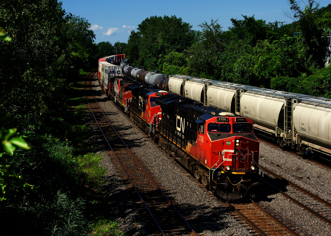 CN 120 has two ET44ACs and two GP38-2Ws up front as it passes cars to be lifted later in the day by CN 400.