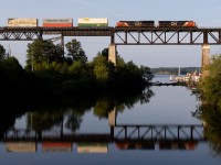 Just after sunrise, the first of 2 back to back stack trains creates a nice reflection in the Seguin River.