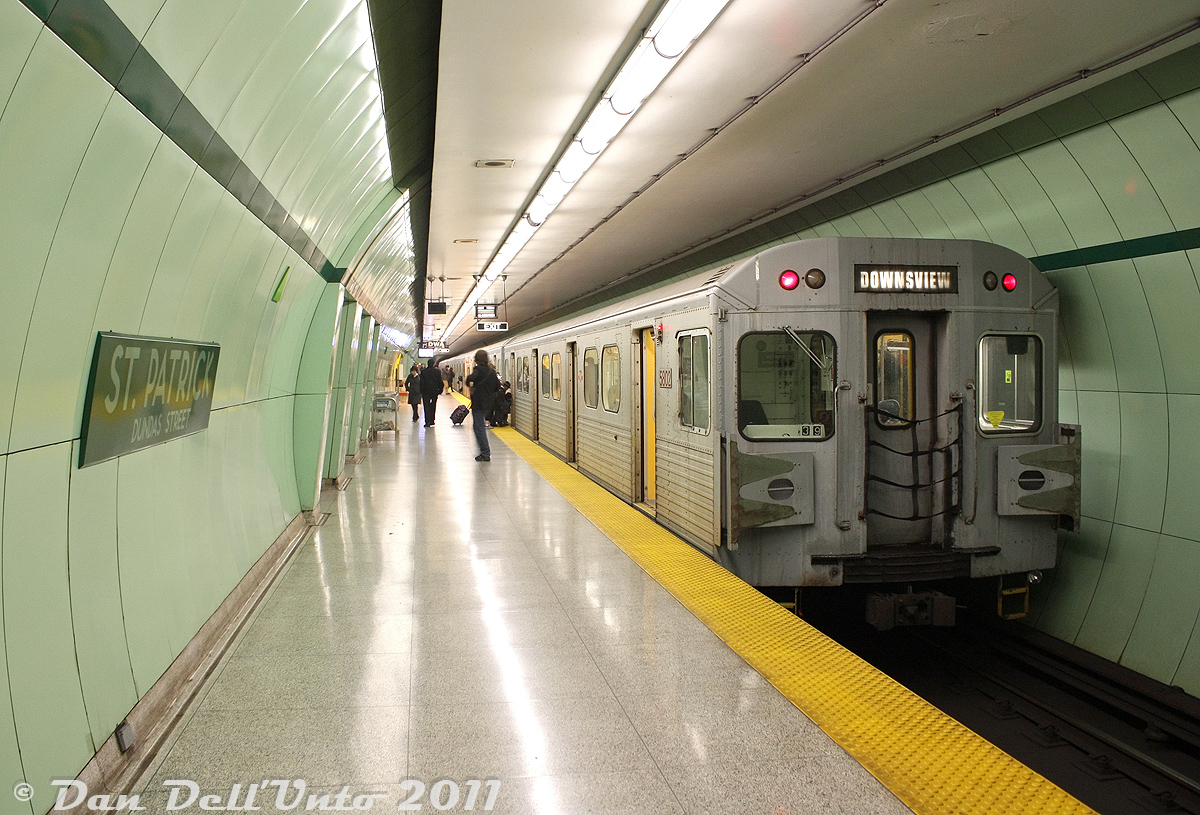Back when the first of the new Bombardier Toronto Rocket subway cars were starting to be delivered and undergo testing, the writing was on the wall for most of the TTC's old 1970/80's-era H4, H5 and H6 subway car fleets. While some elected to wait until the final few trains and final runs, others took the "bird in the hand approach" and got their photos while the going was good (the final Hawker Siddeley H5 cars retired in June 2013).

Here, TTC H5 5802 trails a southbound University line train (notes indicate 5701 leading) as it paused at St. Patrick subway station (Dundas Street) before heading south. St. Patrick and nearby Queen's Park were two unique stations on the University Line where the platform areas were just built in the TBM-bored tunnels, as opposed to using the cut-and-cover construction style for the entire station area like other stops along the early 1960's line. Some parts of the station had wall panels removed for maintenance, revealing metal tunnel lining sections underneath that were stamped for Canada Iron Foundry (Canron), with various October 1960 casting dates.