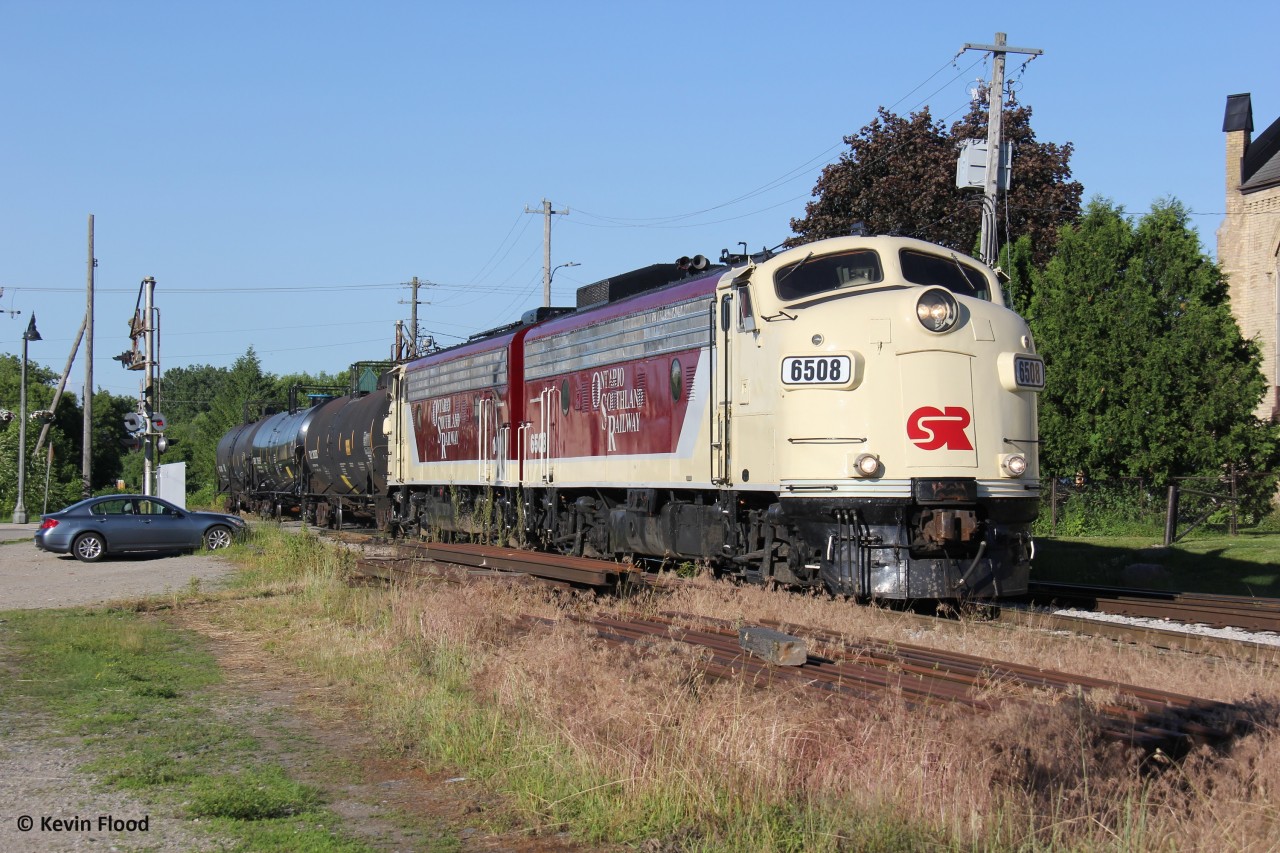 An OSR train is pictured crossing Thames St. in Ingersoll with F-units 6508 and 1401 and three tank cars.