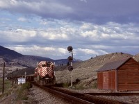 Access to Semlin between Walhachin and Ashcroft was by a rough Barnes Lake Road, but well worthwhile for the views possible.  Here, westbound coal loads symbol 803 with 5809 + 5800 on the headend plus mid-train remotes is lifting from the siding and passing milepost 39 after meeting an eastbound on Sunday 1980-06-08.