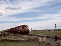 CP’s Montana subdivision runs generally southwest from the Lethbridge area to a BNSF interchange at Coutts/Sweetgrass, with two junctions at Stirling.  The nearer switchstand is for the Stirling sub. seen exiting to the left, and the farther one is for the Cardston sub. visible exiting to the right, as a Coutts Turn with 5810 + 5801 + 5759 + 5813 passes the old water tower foundation heading for Lethbridge on Friday 1989-05-26 at 1522 MDT.

Nowadays, the Stirling sub. is only a spur, reaching 49 miles eastward to Foremost, and the Cardston sub. is disconnected right at Stirling per https://maps.app.goo.gl/j52QTLsaV2Hv8oUu5?g_st=im.
