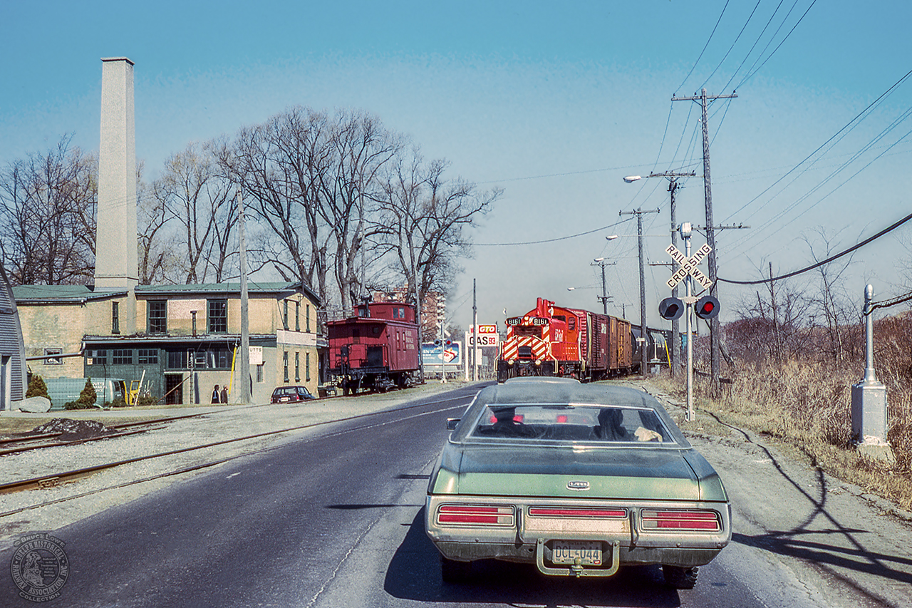 Bruce Lowe captured CP's Simcoe Sub wayfreight along the former Lake Erie & Northern Railway as it crosses Water Street, Highway 24 at the south end of Galt.  On the spur at left is former Canadian National Railway caboose 78444, lettered for the fictitious Nith River, Grand Valley & Southern.  The caboose, owned by a business executive, was used as a private poker room, eventually being relocated to Oakville in 1990.  After bouncing around in private ownership, the trackside guide lists it as surviving on a farm near Elora.