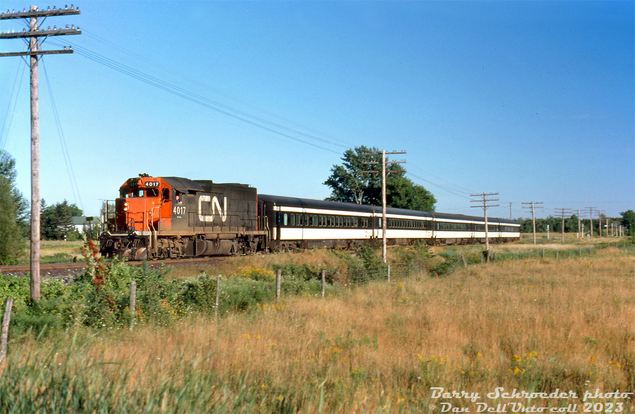 Codeline poles fly by as CN GP40 4017 speeds northbound on the Newmarket Sub leading 5 old 6-axle commuter coaches on the "Barrie Bullet" somewhere south of Barrie. The exact location of this photo isn't noted, but it appears to have been shot between two rural crossings relatively close together.

The two 89mph-geared CN GP40 units (4016 & 4017, later 9316 & 9317) did time on CN and later VIA's passenger trains, and even worked in GO Transit commuter service for a time. One of the assignments they often drew was the "Barrie Bullet" commuter trains between Toronto and Barrie. One of the 3000hp units was pretty much enough, and it lead long hood forward on the trip back.

Barry Schroeder photo, Dan Dell'Unto collection slide.