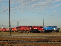 As viewed from F1 Road that runs through the middle of the yard, a gaggle of CP locomotives is gathered just outside the diesel shop at CP Agincourt Yard on September 20, 2016. A splash of blue breaks up the otherwise CP red dominance. Quite the variety of paint schemes and CP logos to see here.