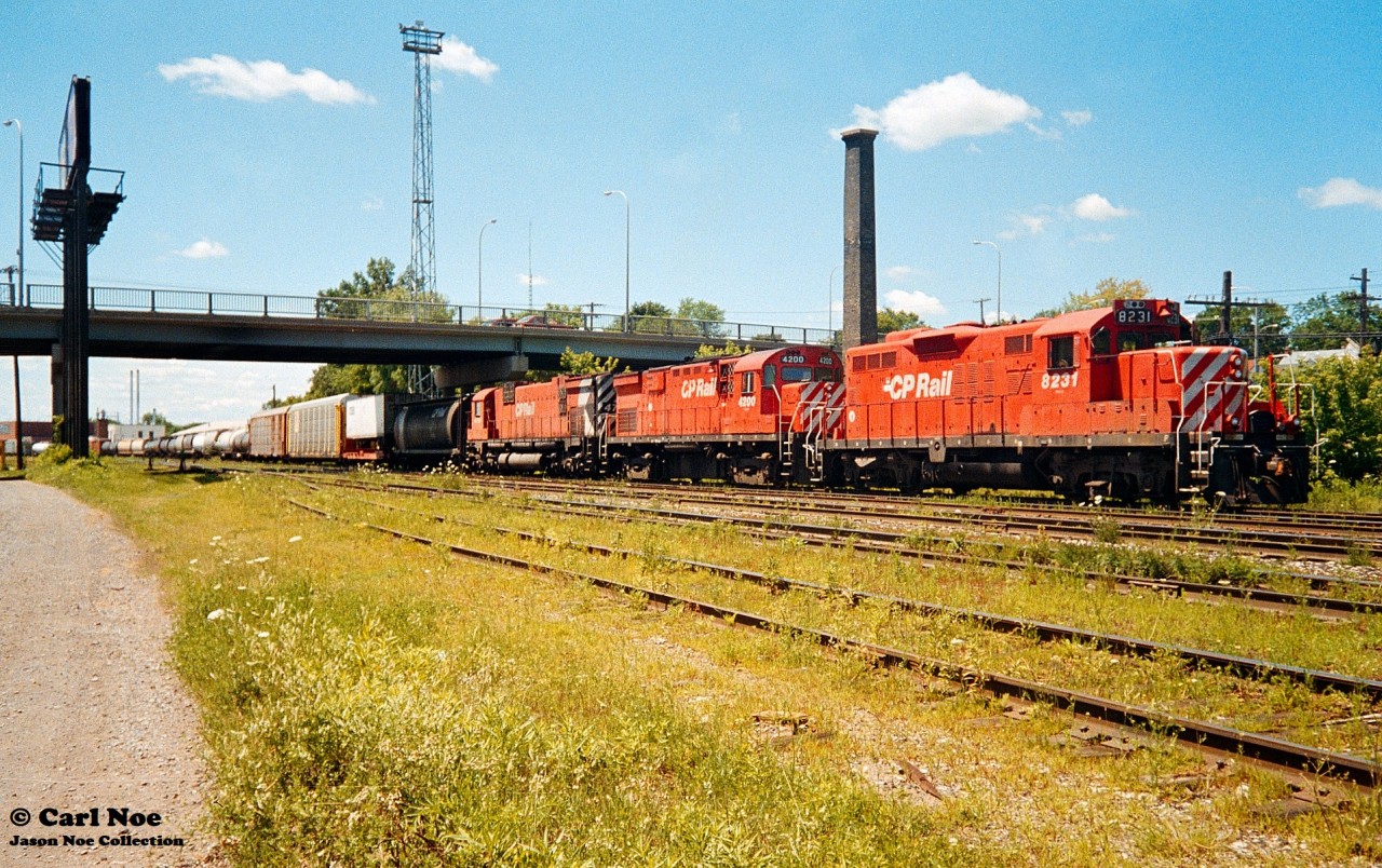 A Canadian Pacific eastbound waits to depart on the Galt Subdivision at the Quebec Street yard in London, Ontario with 8231, 4200 and 4704 for power. This train was possibly 904, which was always a good bet for MLW power. July 17, 1993.