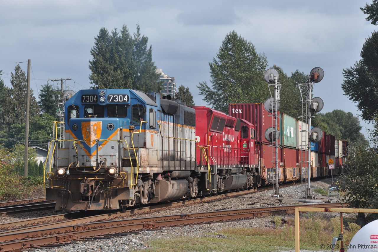 DH 7304 and CP 5015 split the MP 112.9 signals with a train of head-end intermodal well cars followed by grain hoppers, at location Westwood in Coquitlam BC.
The train is westbound (compass north-west) out of Port Coquitlam Yard on the CP Cascade sub, heading toward the Burrard Inlet container terminals and grain elevators near downtown Vancouver.
Westwood (Street) is the northwest control point of the wye where CP Westminster sub (at right) joins the Cascade sub.