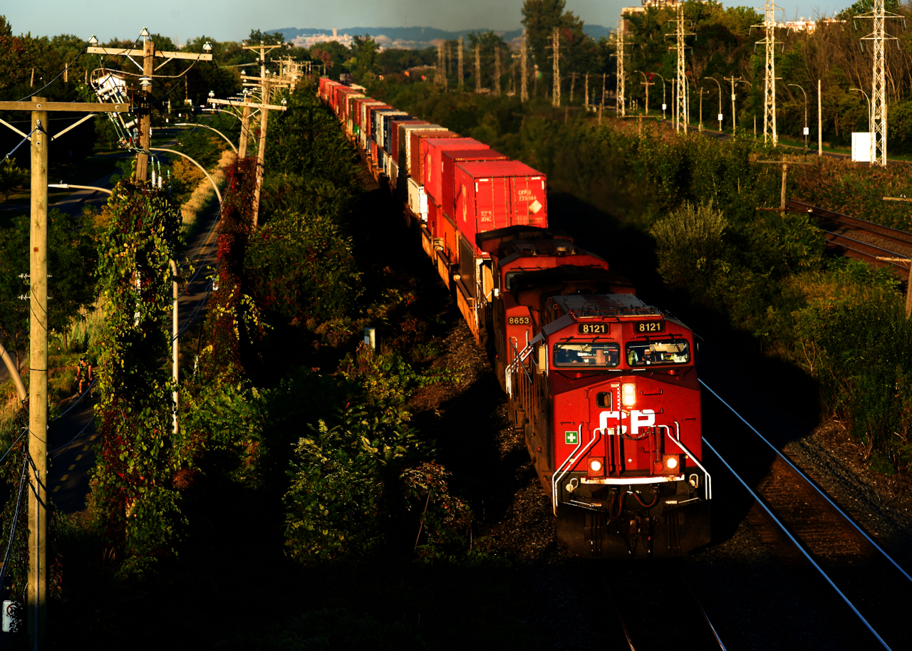 CPKC 119 is 52 feet short of 14,000 feet in length as it heads west near sunset with CP 8121 & CP 8653 up front and CP 9800 mid-train.