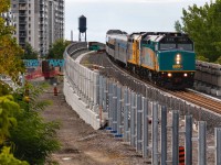 If you were a fan of my previous work on the Davenport Diamond Guideway, (First historical VIA 1 on the Guideway: <a href="http://www.railpictures.ca/?attachment_id=51598"> http://www.railpictures.ca/?attachment_id=51598 </a> ) this serves as more of a follow-up shot to capture the "Metrolinx"-style change seen with the composition of this location. The first thing you might notice is that the unfinished noise barrier construction that had barely even started in April has neared completion. Additionally, the old ground-level Newmarket Sub trackage has completely disappeared since the tearing up of the diamond in June, along with the searchlight that protected it. The only redeeming feature of this spot remaining seems to be the unique angle of the Canadian GE water tower with the modern Newmarket Sub. Now that this location has suffered from some overgrowth in the summer, the increasing difficulty of this shot seems only worthwhile for historical value. I may revisit once the Guideway project achieves true completion and the right-of-way is converted into green space (assuming said green stays out of the way from this angle :) ).