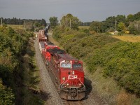 The sky behind the camera on September 17th was very patchy with clouds, and the sun was fading in and out.  I had been chasing this train from London all the way to Woodstock with the intention of catching it here at the bridge on the west end of the town.  Just as the train rolls by, the clouds part and the sun shines on the front of CP 8027 as it leads train 230 eastbound on the Galt Subdivision.  In the trailing position was SD30C-ECO number 5030, and mid-DPU was KCS ES44AC 4837.  