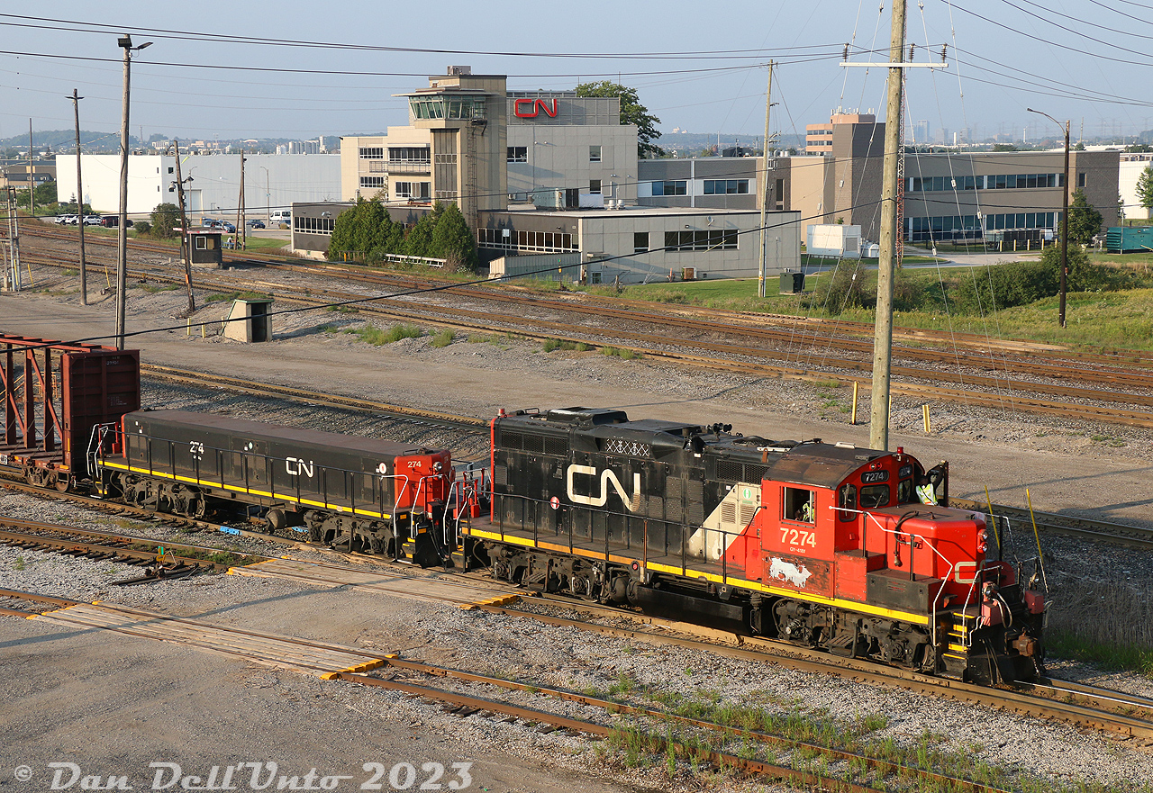 CN GP9RM 7274 and slug 274 switch cars at the south end of CN's sprawling MacMillan Yard in Vaughan, after switching out the lumber facility at the west end of the yard. CN's yard administration building is visible in the background, built in the 1960's when the whole yard was new.

With 68 and 66 years of service for their original owner (7274 originally built as GP9 4595 in June 1957, and 274 originally built as CN GP9 1746/4422 in April 1955), it's hard to believe both of these units worked alongside the last of the steam locomotives in Canada, and are still at it putting in a full day's work decades later.