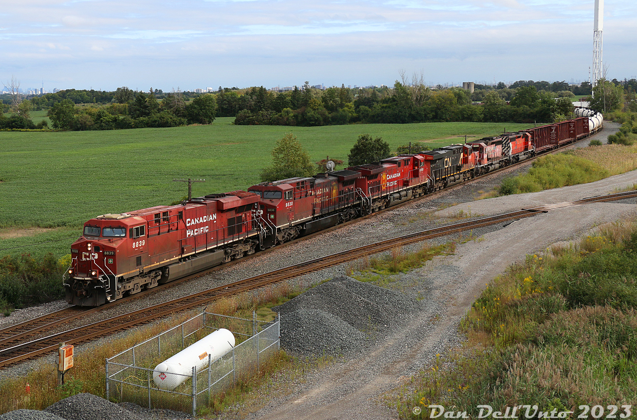 CPKC's "Friday Night Special" #421 heads north up the MacTier Sub at Elder with a long train lead, by a nice mix of power up front: CP ES44AC 8839, oily AC4400CW 9830, clean AC4400CWM 8200, borrowed CN ES44AC 2923, and old SD40-2's 6028 (in ratty faded pink System paint) and 6055 (multimark!). If one looks carefully, they can see the ever-present CN Tower from here.