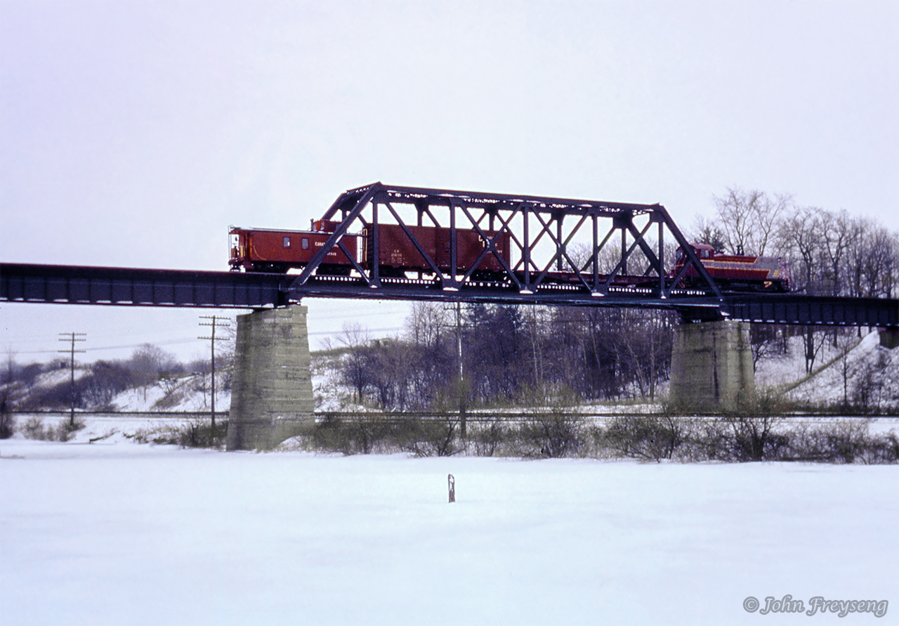 Canadian Pacific's Simcoe wayfreight rolls southbound along the former Lake Erie & Northern Railway, crossing the bridge over New York Central's CASO mainline.  The GMD SW8 was sold to Ogeechee Railroad of Georgia in 1989 as their 101, and is still operating today, once again wearing it's original number.Scan and editing by Jacob Patterson.