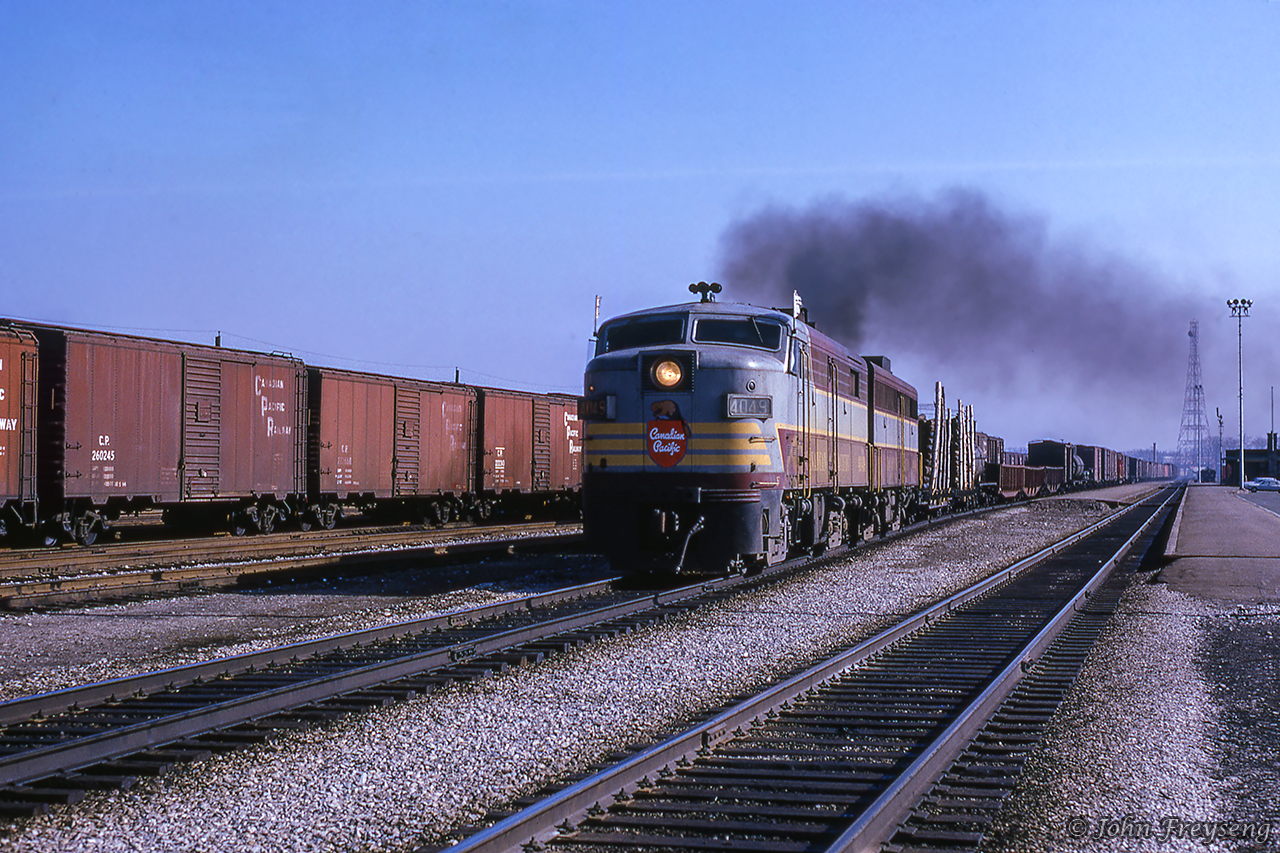 A London-bound extra behind MLW FA-2 4049 and FB-1 4401 lays down some smoke while passing Leaside station.  Lead unit 4049 will be retired and scrapped in 1972 after suffering a fire along the Heron Bay Sub west of White River.