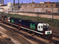 A pair of SW1200RS switchers and two of GO Transit’s initial eight GP40TC diesels, originally numbered 600-607 (final renumbering 500-507 in 1975) are backing into CNR Bathurst St. freight yard to couple up to a transfer and take it to Vaughan Yard. These diesel units were basically a 3000hp GP40 built with a lengthened frame to accommodate the auxiliary engine/generator (HEP). They arrived from GMD in London several months before GO train debut between Pickering-Toronto Union-Oakville, May 23, 1967).  I first saw these at CN's Toronto Yard as seen here on <a href=http://www.railpictures.ca/?attachment_id=52568>January 28, 1967.</a><br><br><i>John Freyseng Photo, Jacob Patterson Collection Slide.</i>