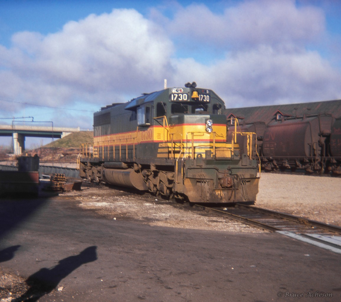 The morning of Sunday, November 13, 1977 finds ONR SD40-2 1730 sitting at the north end of the North Bay shops, while Members of the Upper Canada Railway Society capture a few photos.UCRS members were up north for the weekend, having taken train 123, the Northlander, from Toronto on Fri. Nov. 11 up to North Bay.  The excursion on Sat. Nov. 12 ran to Elk Lake, Adams Mine, Swastika, and Kirkland Lake, returning to North Bay later in the evening.  Members would return south to Toronto on Northlander 122 on Sunday afternoon.  More details of the weekend's event can be found in the March-April 1978 UCRS newsletter.Today, ONR 1730 once again wears this scheme as ONR's heritage unit.