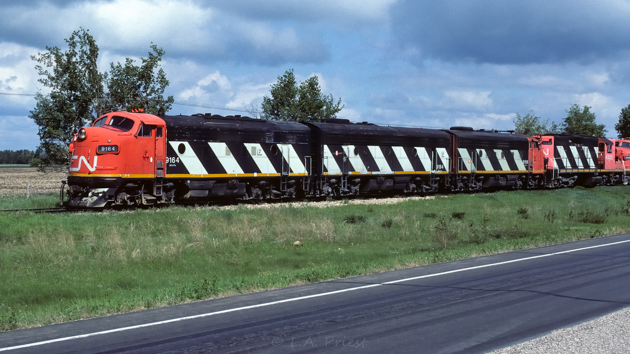 Did I hear a request for Lac La Biche? Here is a weeks worth and it will help tie some of my photos together. To start, quite awhile ago I posted an odd ball consist of the 9160, 9190 and 1081. This was a work extra heading out on Thursday, May 23rd at 9:30. Next, on Sunday the 26th, a unit train of 33 empties heads out with the 4602, 5578 and 5606. The next day Monday the 27th, another unit train heads out with the 5590, 9194, 9107 and 9159 as a cabhop at 8:30 (posted this just a few weeks ago). Later on Monday at 17:30, it is the return of the 5606, 5578, 9190 and 1081 with 34 sulphur loads (another odd consist). On Tuesday at 16:00 the 5590, 9194, 9107,and 9159 return with 50 loads. At 11:00 on Wednesday the 29th will be the photo I just posted of the 9159, 9194 and 9164 heading out with a bunch of empties. Later on Wednesday at 21:00, the Muskeg Mixed heads out with the 4332 and 4214. Which brings us to this photo, Friday the 31st at 11:30, with the 9164, 9194, 9159, 4332 and 9160 (way at the back). It is just sitting clear of the north connecting track switch at Egremont. Waiting for 836 to pass through Kerensky. They have 35 loads and caboose 79764. Later on Friday at 22:00, it is the return of the Muskeg Mixed with a single 4214. The only unit remaining up north was the 4602, from the 26th, and it snuck by at some point without my seeing it.