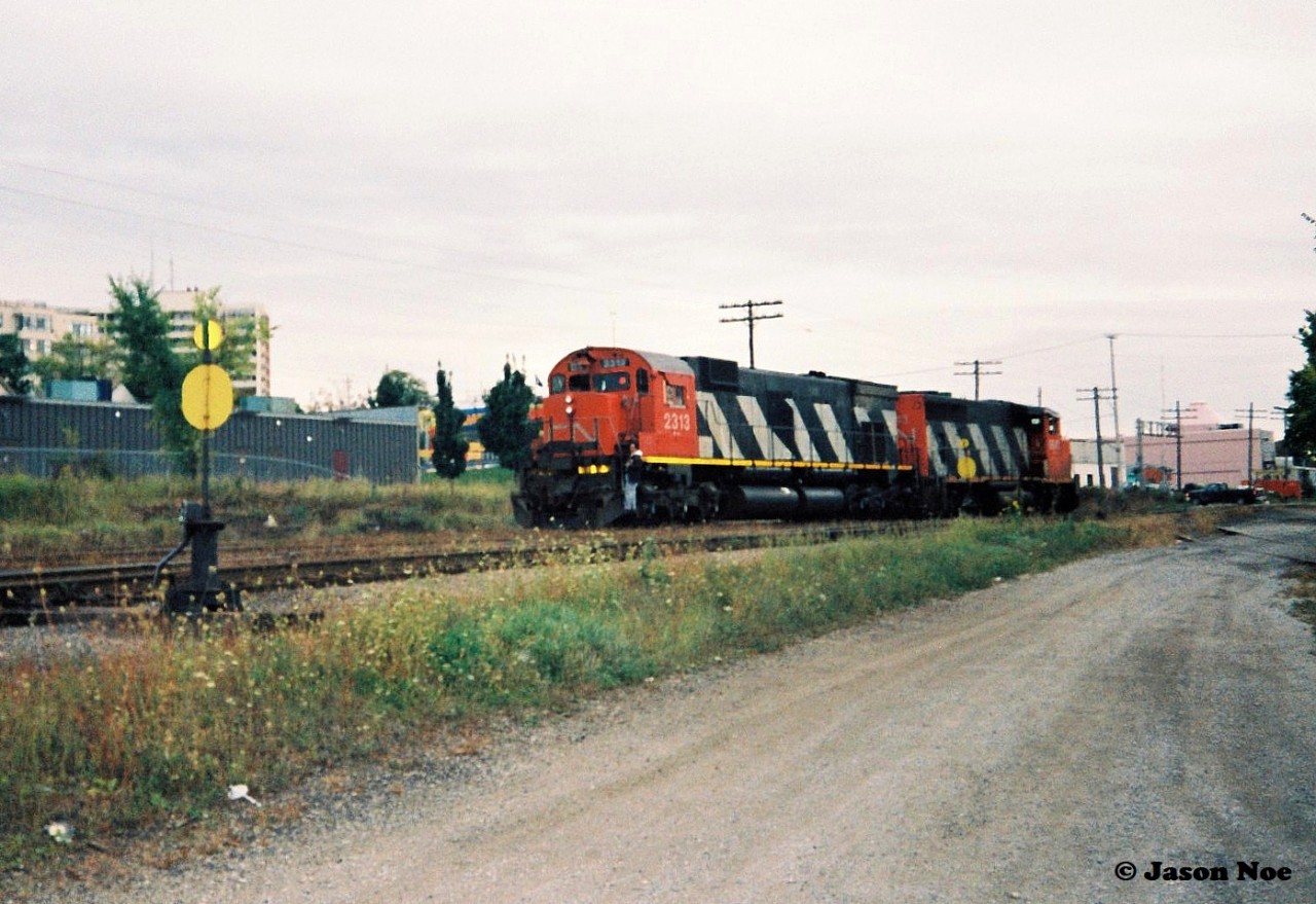 During an overcast evening, CN 421 is seen after setting-off their cars in the Kitchener yard with GP40-2L(W) 9643 and M-636 2313. The move allowed for an un-coupled view of the trailing big MLW.