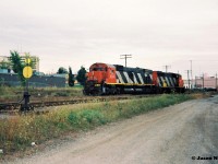 During an overcast evening, CN 421 is seen after setting-off their cars in the Kitchener yard with GP40-2L(W) 9643 and M-636 2313. The move allowed for an un-coupled view of the trailing big MLW. 
