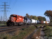 CP SD40-2 5846 and MKCX SD45 9523 lean into the curve at Lambton Mills as they leave the West Toronto area with train #511, westbound on the Galt Subdivision in the afternoon. MKCX 9523 was one of locomotive rebuilder Morrison Knudson's many lease units, in this case a former CSX unit still in CSX paint (originally built for the Seaboard Coast Line, and eventually ending up as Wisconsin Central 6636).
<br><br>
This location at Lambton Mills also has significance in that it was where the old <a href=http://www.trainweb.org/oldtimetrains/TSR/guelph_radial.htm><b>Toronto Suburban Railway</b></a> interurban line from West Toronto to Guelph (operations discontinued in 1931) ducked underneath CP's Galt Sub, before continuing west and crossing the Humber River on a separate railway bridge.
<br><br>
<i>Peter Jobe photo, Dan Dell'Unto collection slide.</i>