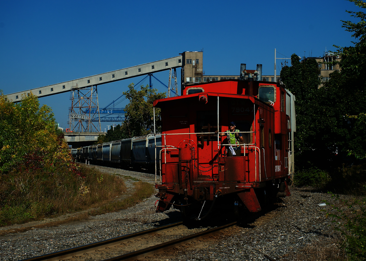 Grain empties are heading to Pointe St-Charles Yard as caboose GTW 79047 leads the westward move.