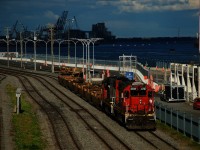 A brief period of sunshine illuminates CN 500 as it leaves the Port of Montreal with a short train of baretables. Power is CN 4727 & CN 4712.