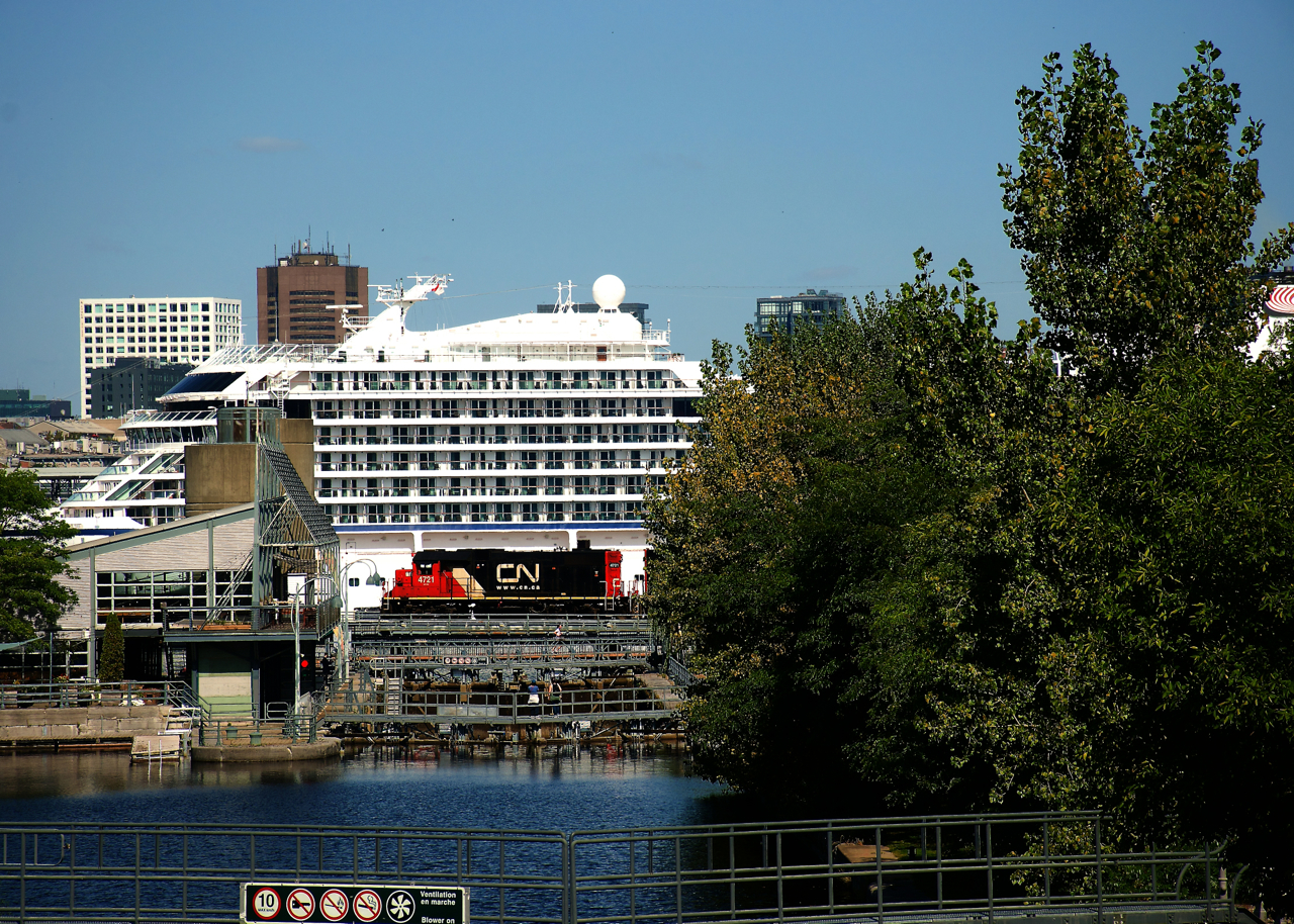 CN 4721 is dwarfed by a cruise ship as it advances over the Lachine Canal for headroom as it switches grain cars.