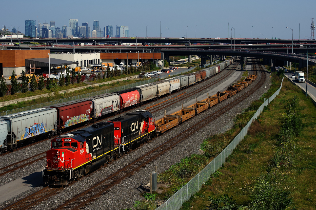 CN 500 has well cars for the Port of Montreal as it prepares to lift most of the grain cars that are seen at the left, which are also for the port.